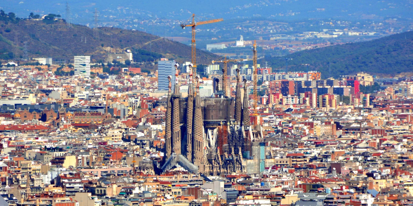Barcelona katuste meri ülalt vaadatuna, keskel kerkib Sagrada Família ja taustal on mäed