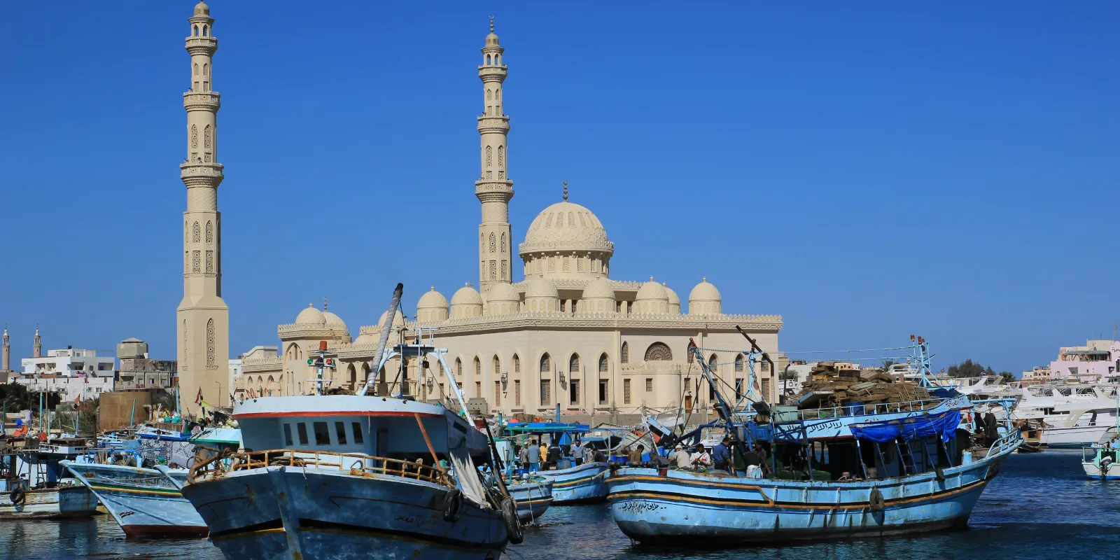 Hurgada sadam: puidust kalapaadid vee peal ja taga heledast kivist mošee kahe minaretiga