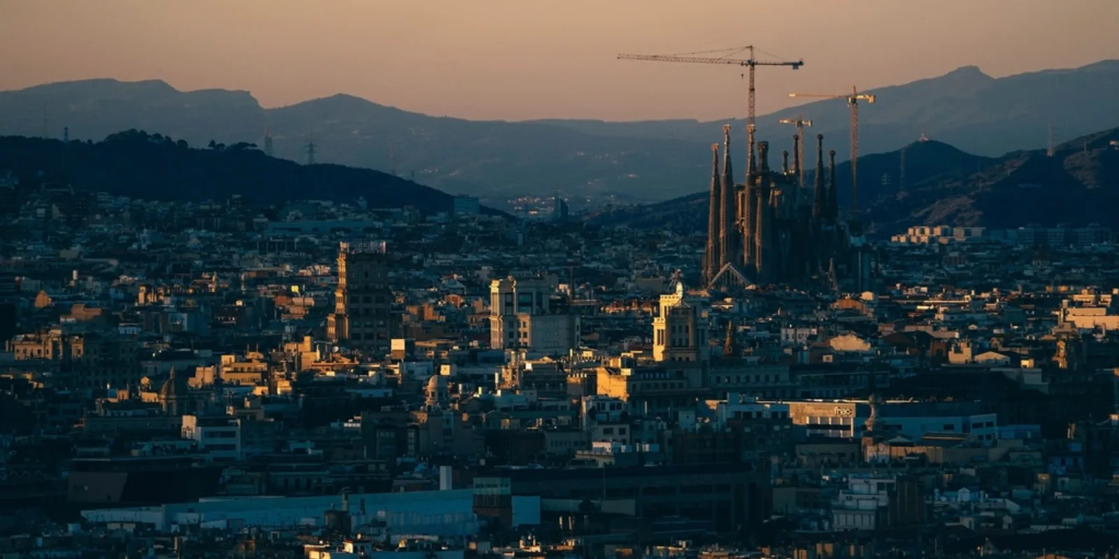 Barcelona linnavaade hämaras, taustal mäed ja Sagrada Família siluett
