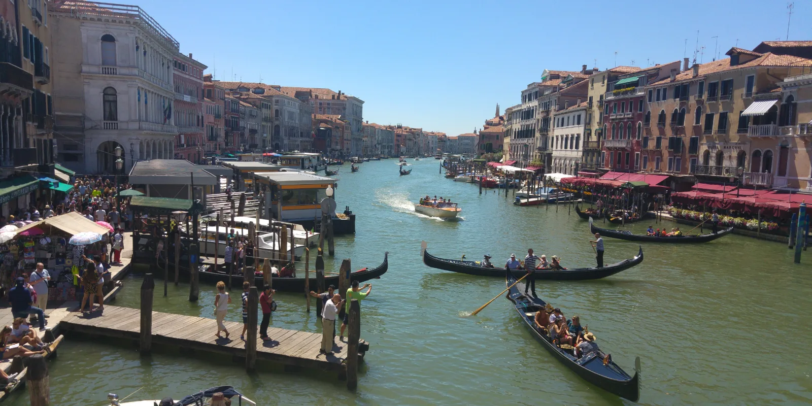 Veneetsia Canal Grande Rialto sillalt: gondlid ja vaporetto rohekal veel, mõlemal kaldal vanad palazzod ja rahvarohke paadisild